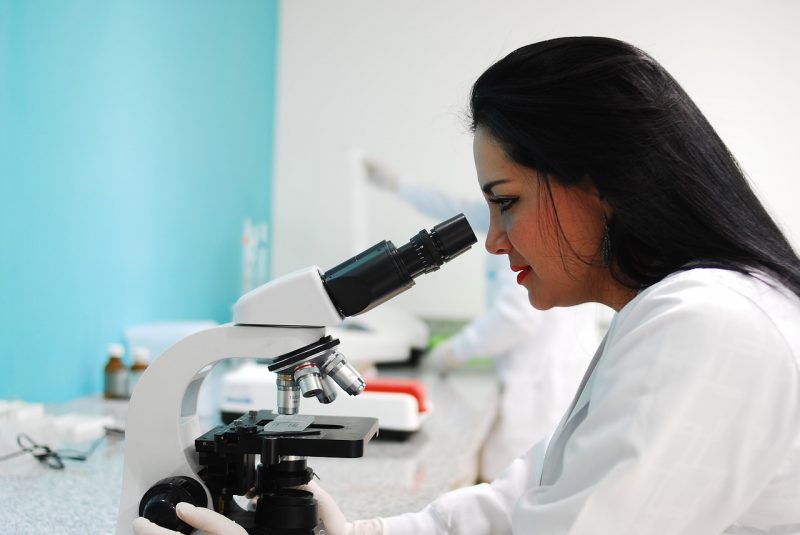 Young woman looking into a microscope.